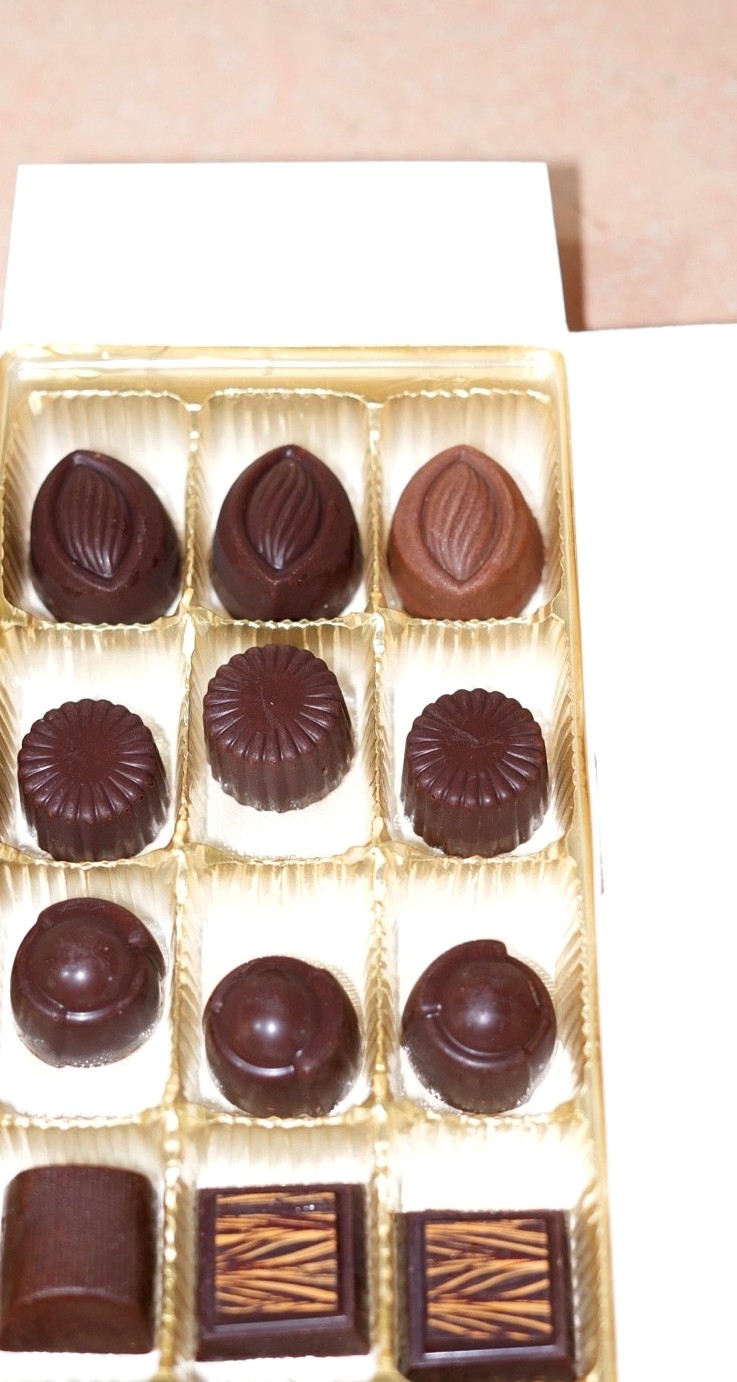 Assorted handmade Ghanaian chocolate pralines in a golden tray